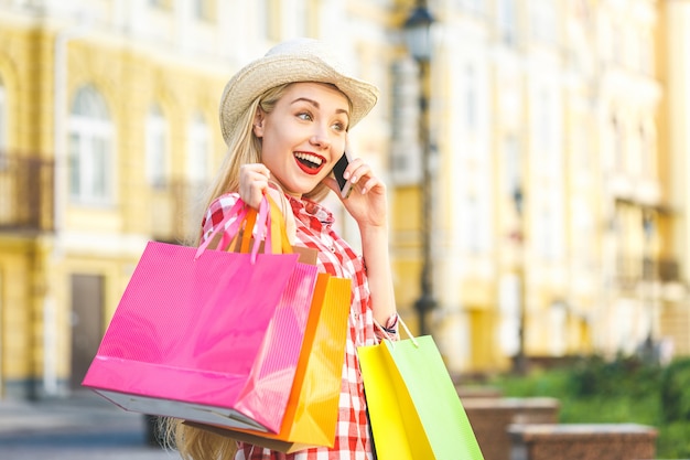 Donna felice con i sacchetti della spesa che gode nello shopping.