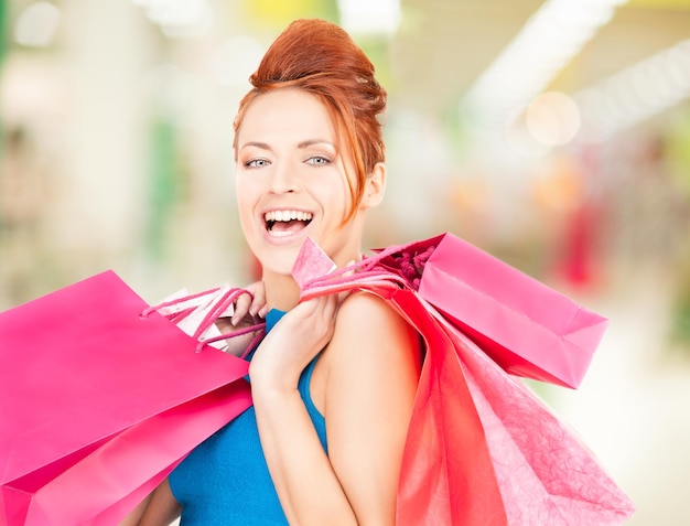 モールで買い物袋を持つ幸せな女性