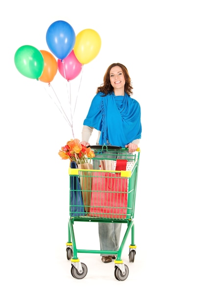 happy woman with shopping cart and balloons over white wall