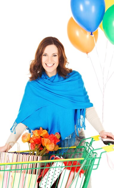 happy woman with shopping cart and balloons over white wall