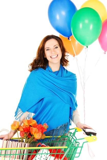 happy woman with shopping cart and balloons over white