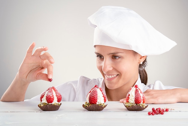 Happy woman with small strawberry pastries