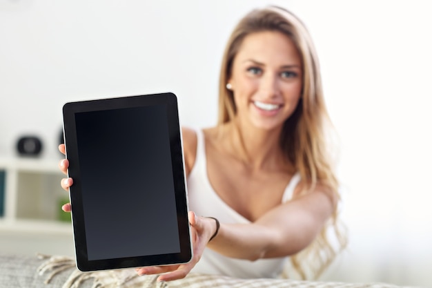 happy woman with tablet on sofa