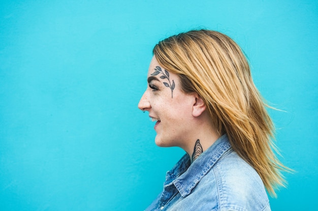 Photo happy woman with tattoos on her face