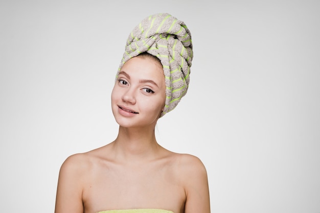 Happy woman with a towel on her head after a shower