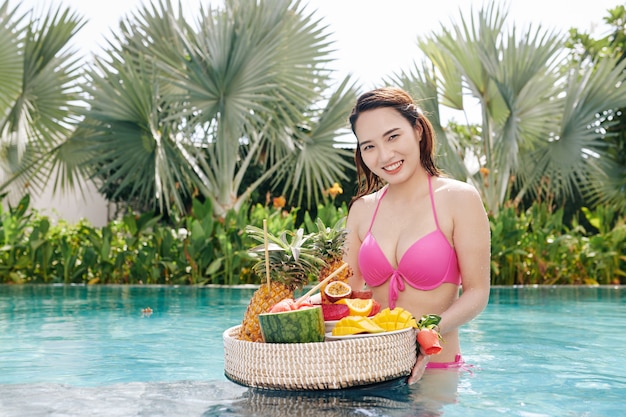 Happy woman with tray of fruits