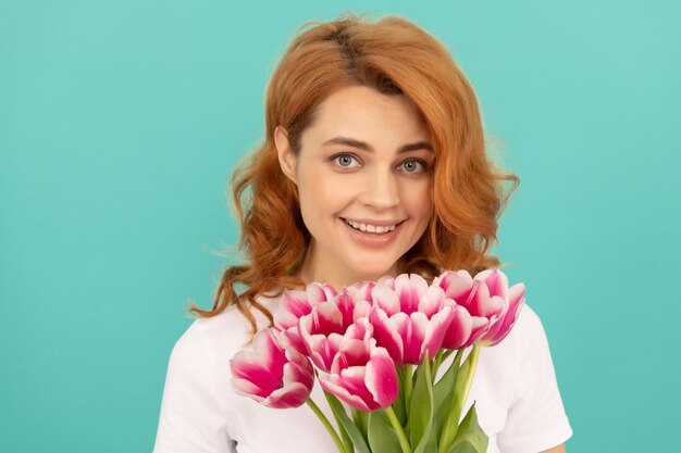 Счастливая женщина с букетом тюльпанов на синем фоне 8 марта