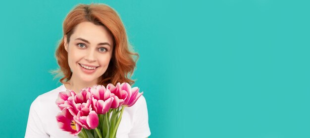 Happy woman with tulip flower bouquet on blue background mothers day Woman isolated face