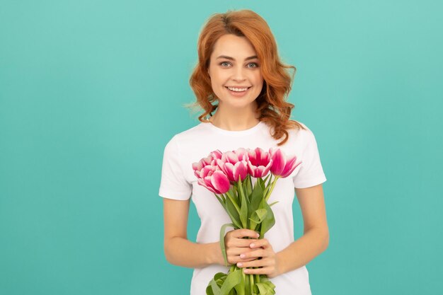 Happy woman with tulip flower bouquet on blue background