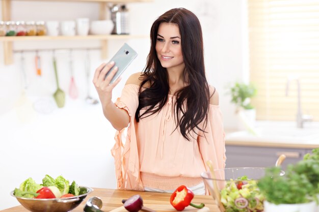 Donna felice con verdure in cucina moderna