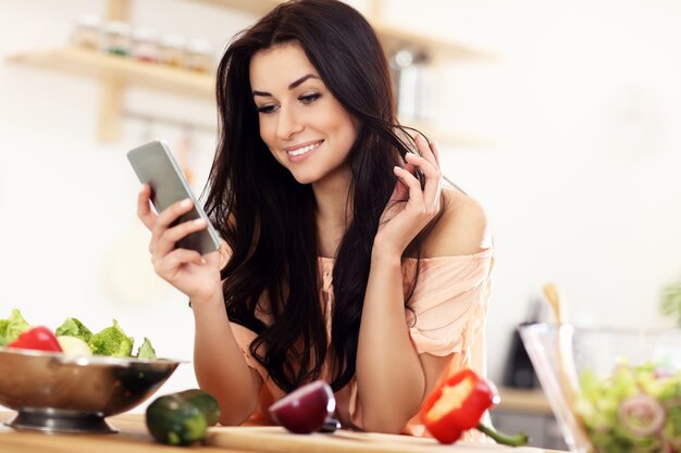 happy woman with vegetables in modern kitchen