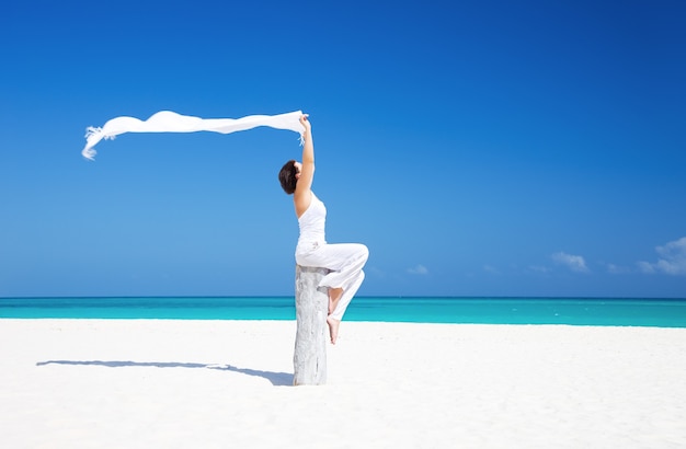 happy woman with white sarong on the beach