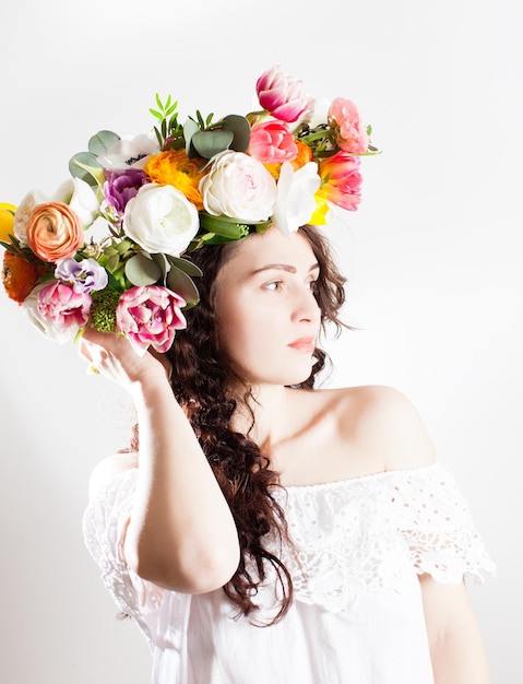 Happy woman with wreath of flowers looking aside isolated on a white background