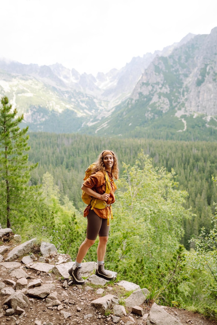 Photo happy woman with a yellow hiking backpack enjoying the mountain landscape travel concept
