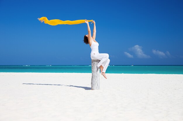 happy woman with yellow sarong on the beach