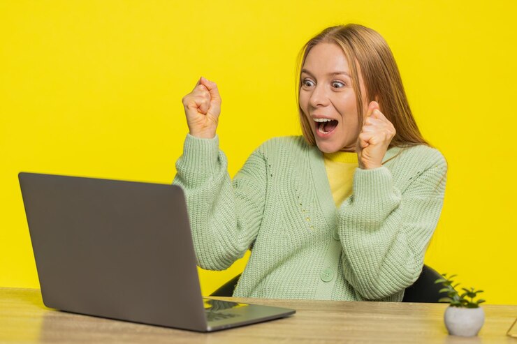 Photo happy woman working on laptop shocked by victory celebrate winning goal achievement good career news