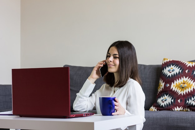 写真 自宅のラップトップに取り組んで幸せな女。