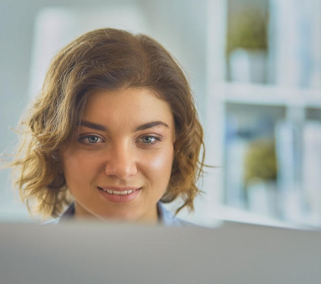 Happy woman working using multiple devices on a desk at\
home