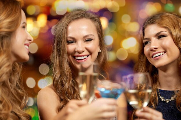 ナイトクラブでグラスを鳴らす幸せな女性