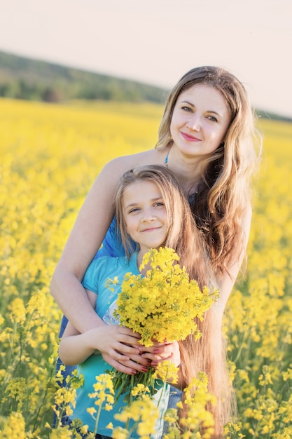 Happy women and girl in rape field