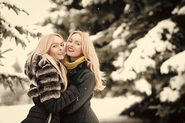 Happy women hugging outdoors on winter day