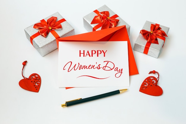 Foto happy women's day-kaart met rode envelop en geschenken op witte achtergrond, 8 maart