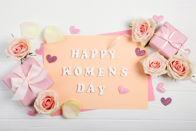 Happy Women's Day text on cardboard with roses, hearts and gifts