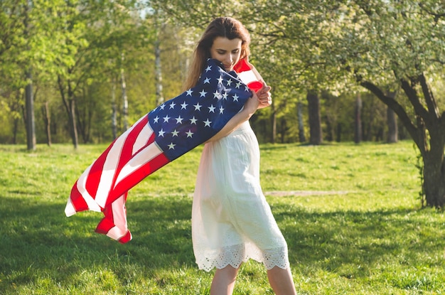 Le donne felici con la bandiera americana usa celebrano il 4 luglio