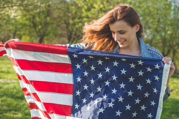 Le donne felici con la bandiera americana usa celebrano il 4 luglio