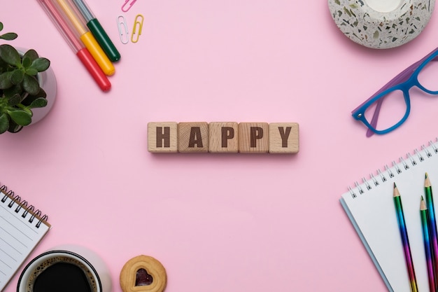 Happy at work concept composition at office workspace on pink background