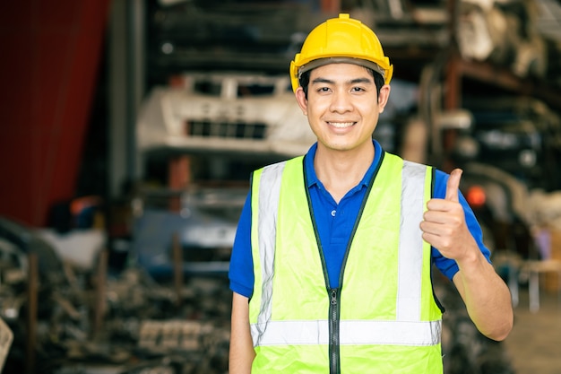 Happy worker Asian male man with safety suit work in engineering factory hand thumbs up sign