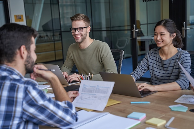 Happy workers on conversation in conference room