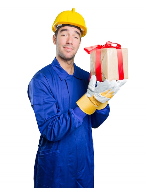 Happy workman holding a gift on white background