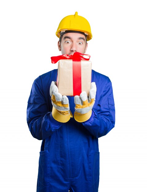 Happy workman holding a gift on white background