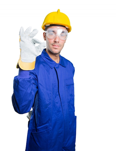 Happy workman with an okay gesture on white background