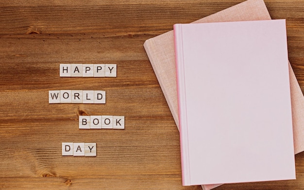 Фото Счастливого всемирного дня книги с бумагой и столовой карточкой с сообщением на столе