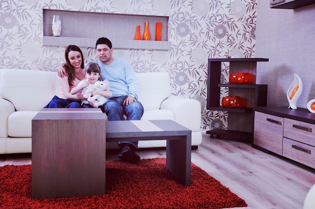 счастливая молодая семья отдыхает в современной гостиной дома