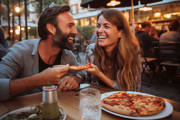 Happy young adult couple have fun eating a pizza together outdoor in traditional italian pizzeria restaurant sitting and talking and laughing People enjoying food and dating relationship Tourists