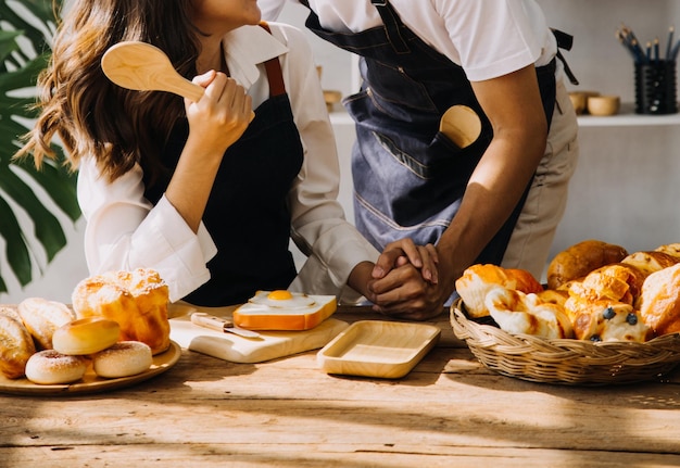 Happy young adult couple making breakfast and drinking coffee together in cozy home kitchen in morning at home Preparing meal and smiling Lifestyle leisure and Love concept