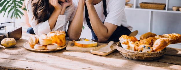 Happy young adult couple making breakfast and drinking coffee together in cozy home kitchen in morning at home Preparing meal and smiling Lifestyle leisure and Love concept