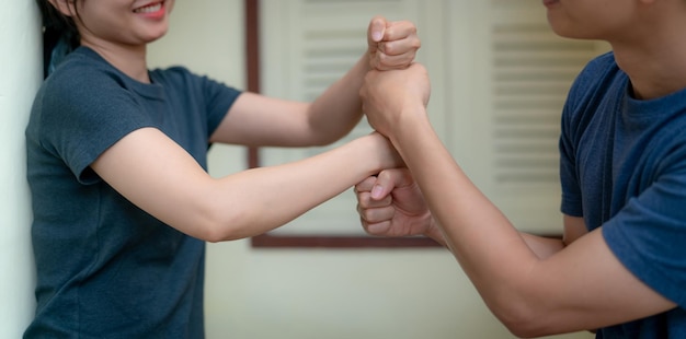 Felice giovane coppia adulta che si mette i pugni uno sopra l'altro e sorride felice matrimonio