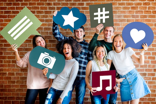 Photo happy young adults holding thought bubble with social media concept icons