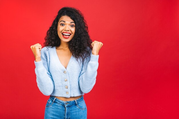 happy young african american black woman isolated over red background