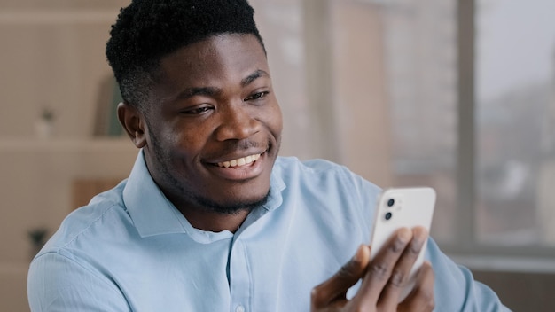 happy young african american guy businessman handsome entrepreneur man worker hold smartphone talk