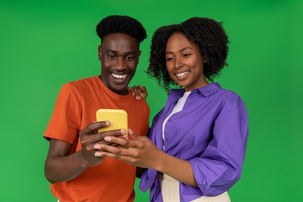 Happy young african american guy showing smartphone to woman recommending app