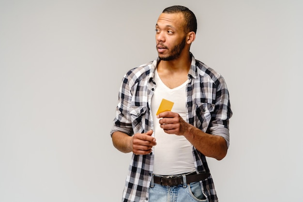 Счастливый молодой афро-американский мужчина держит наличные или дисконтную карту