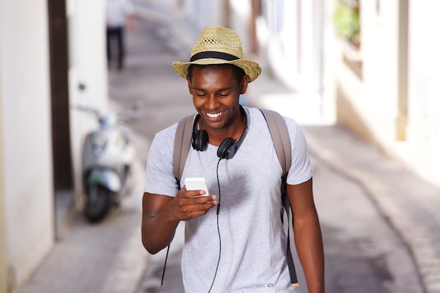 Happy young african american man walking mobile phone