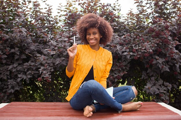 Счастливый и молодой афро-американский студент в парке