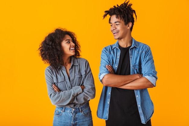 Happy young african couple wearing casual clothes standing isolated, arms folded