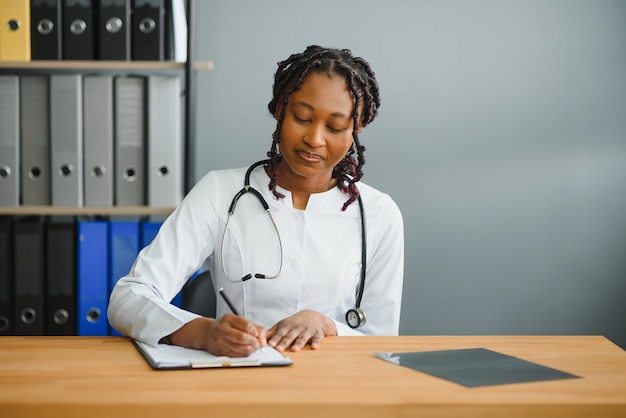 Happy young african female nurse working in office